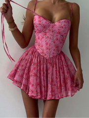 Pink floral dress worn by a person against a plain background