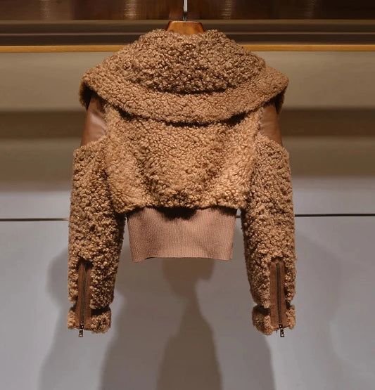 Brown shearling jacket with leather accents on a hanger against a neutral background