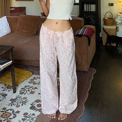 Person wearing light pink floral pajama pants in a living room.