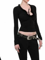 Person wearing a black long-sleeve top and black pants with a decorative belt 