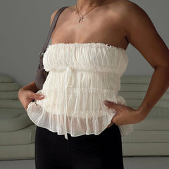 Woman wearing a white ruffled top with a blurred background