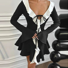 A woman wearing a flattering black mini dress with ruffle details, perfect for a party or special occasion.