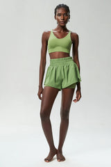Woman wearing a green sports bra and shorts set -full view