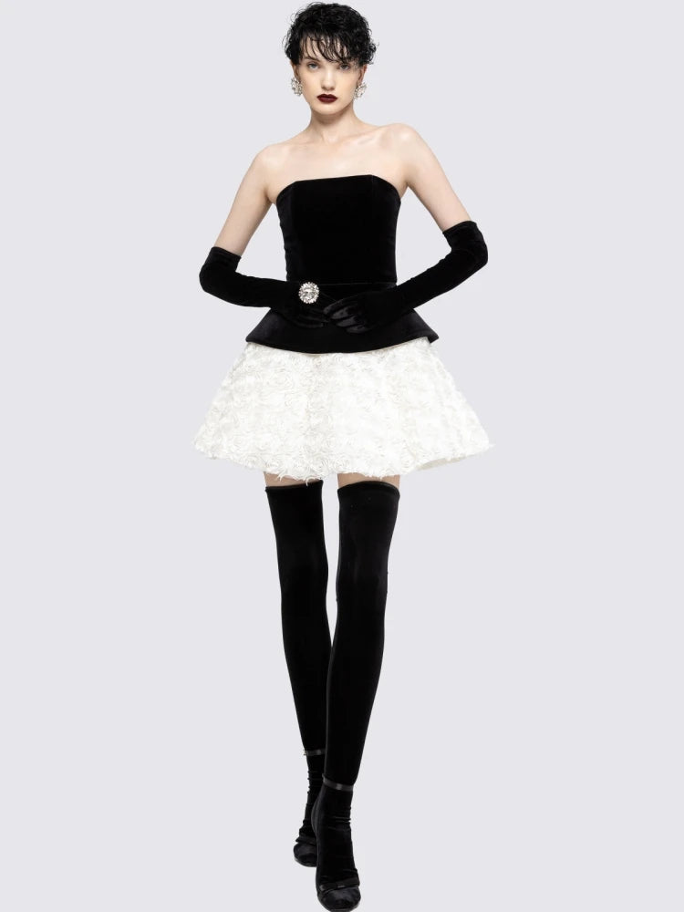 Woman wearing a black strapless top, white skirt, and black knee-high boots 
