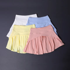 Four colorful skirts (yellow, pink, blue, white) on a dark background