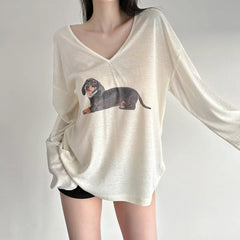 White long-sleeve shirt with dachshund graphic worn by a person 