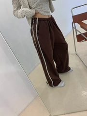 Women's black track pants with lace details.