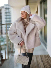 Women's beige faux fur coat with a collar and pockets.