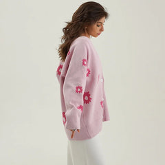 Woman wearing a pink sweater with floral patterns