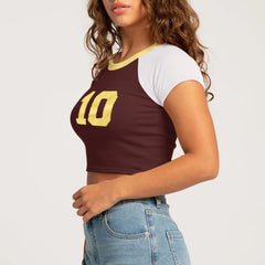 Woman wearing a brown and white crop top with the number 10