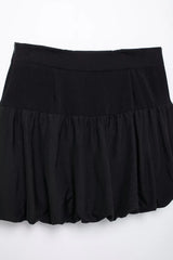 Women's black mini skirt with a balloon silhouette and gold buttons.