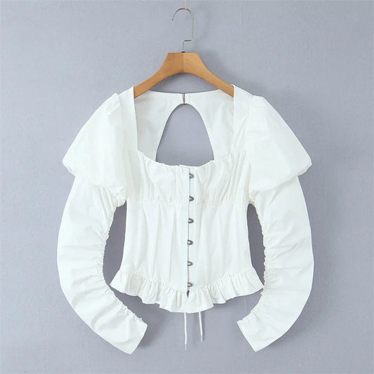 White long-sleeve blouse with puff sleeves, a square neckline, and a back keyhole cutout, hanging on a wooden hanger against a plain gray background.