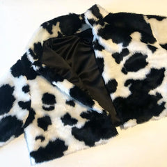 Black and white cow print fabric with a large bow on a white background