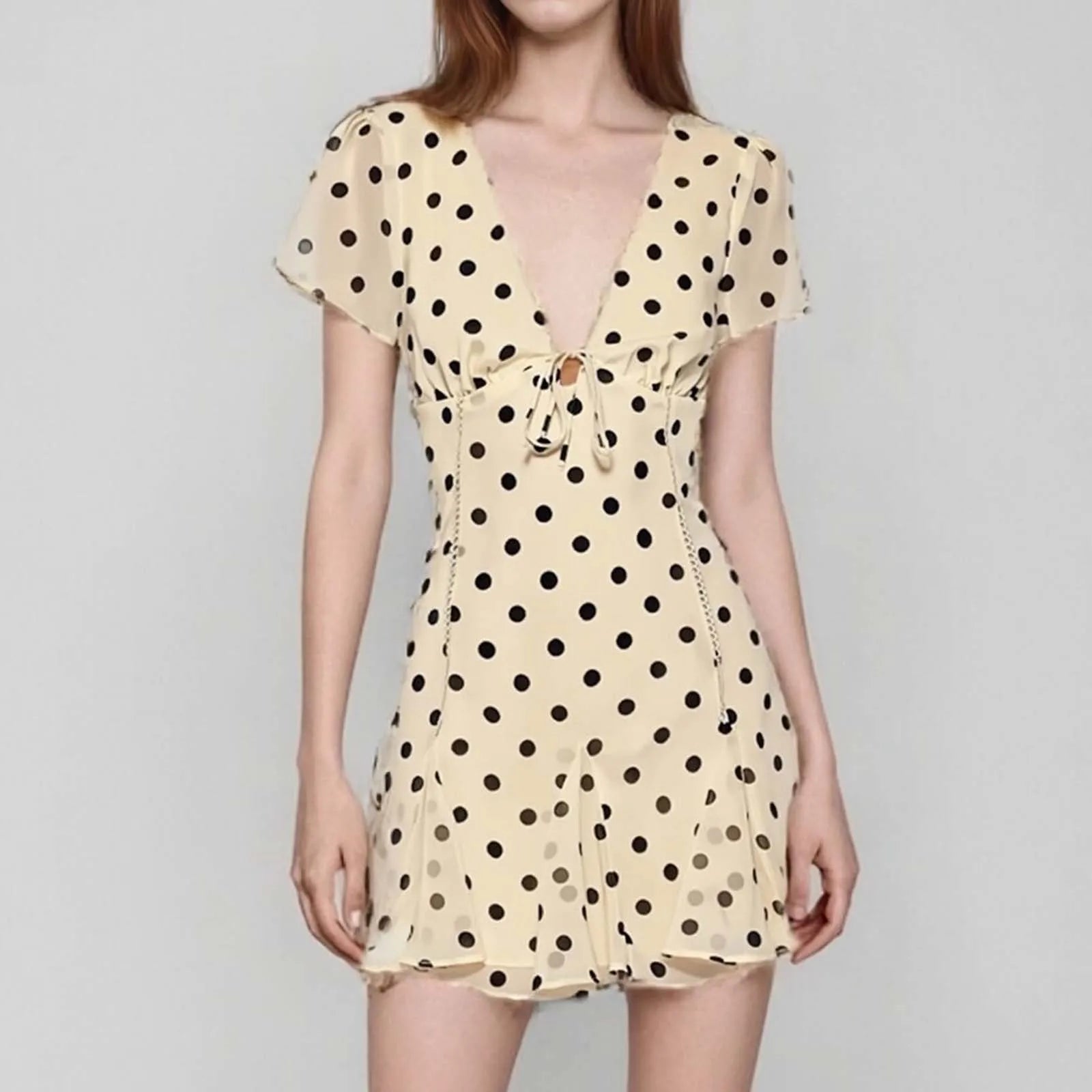 Beige dress with black polka dots on a gray background