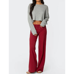 Person wearing a gray cropped sweater and red flared pants 