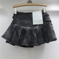 Black denim skirt on a hanger against a white background