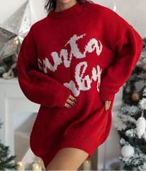 Red sweater with white text worn by a person, Christmas decorations in the background