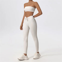 Person wearing a white strapless top and leggings with white sneakers