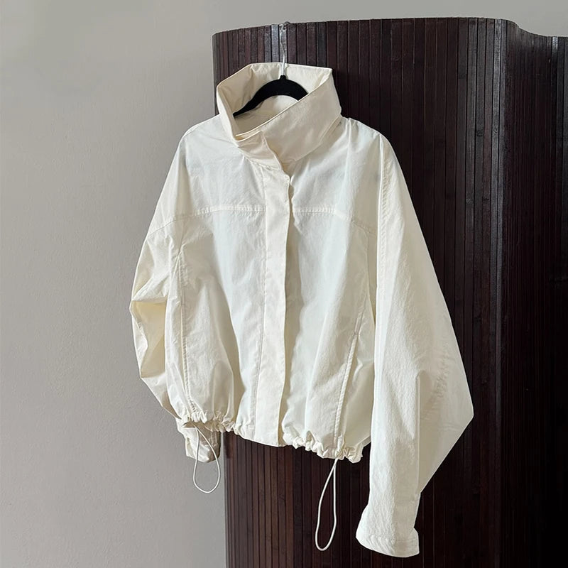 White jacket hanging on a wooden door against a gray wall