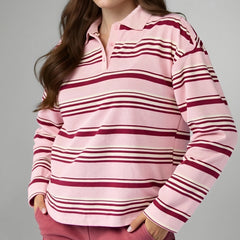 Person wearing a pink and red striped long-sleeve shirt against a gray background