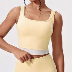 Person wearing a yellow tank top and pants on a white background