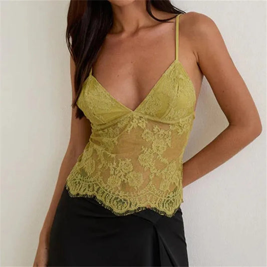 Woman wearing a green lace top against a plain background