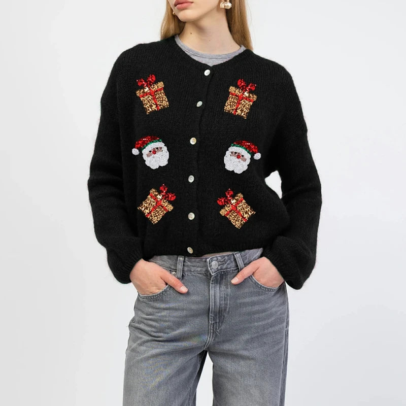 Black cardigan with Christmas-themed patterns worn by a person on a white background