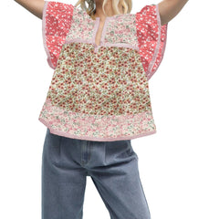 Child wearing a floral top with pink sleeves and blue jeans 