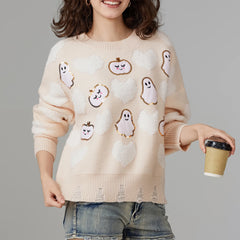 Person wearing a beige sweater with Halloween-themed designs, holding a coffee cup.