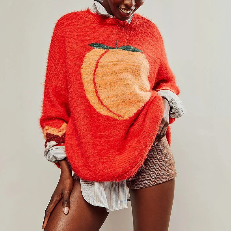 Person wearing a red sweater with a peach design on a plain background