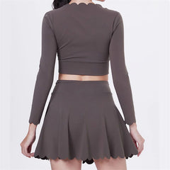 Person wearing a gray long-sleeve crop top and skirt set- back view