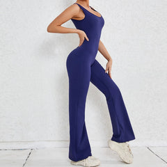 Person wearing a blue jumpsuit against a white brick wall.
