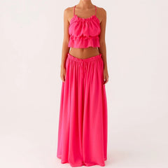 Pink two-piece outfit with a top and long skirt on a white background