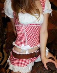 Person wearing a red and white checkered outfit with a white apron.