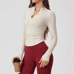 Woman wearing a white long-sleeve top and red leggings holding a coffee cup 