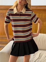 Woman wearing a striped polo shirt and black skirt in a room with wooden paneling.