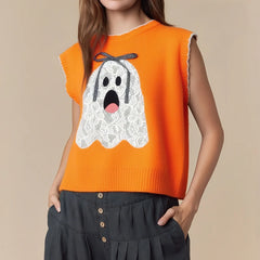 Orange sleeveless sweater with a ghost design worn by a person on a beige background