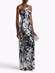 Woman wearing a black and white floral halter neck gown on a white background