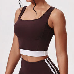 Person wearing a brown sports bra and leggings with white stripes on a light gray background