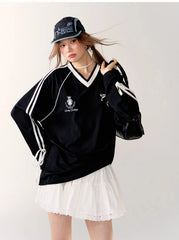 Person wearing a black oversized sweater with white stripes and a white skirt, standing 