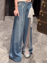 Person wearing blue jeans with decorative elements on a marble floor.