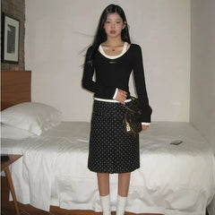 A woman wearing a stylish polka dot midi skirt, showing off its flattering fit and playful design.