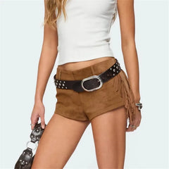 Brown suede shorts with studded belt and fringe detail on a plain background