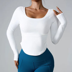 Person wearing a white long-sleeve top and blue leggings on a gray background