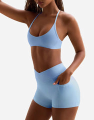 Woman wearing a light blue sports bra and shorts set front view