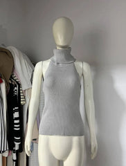 A grey knitted turtleneck top and long sleeve shawl set.