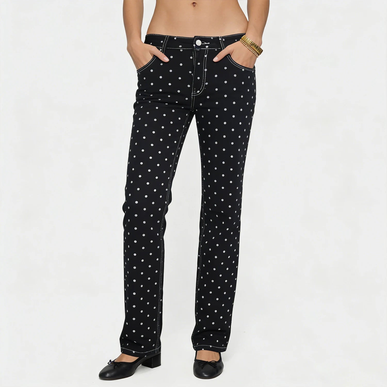 Black jeans with white polka dots worn by a person on a white background