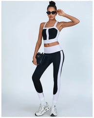 Woman wearing a black and white sports bra and leggings set - full view