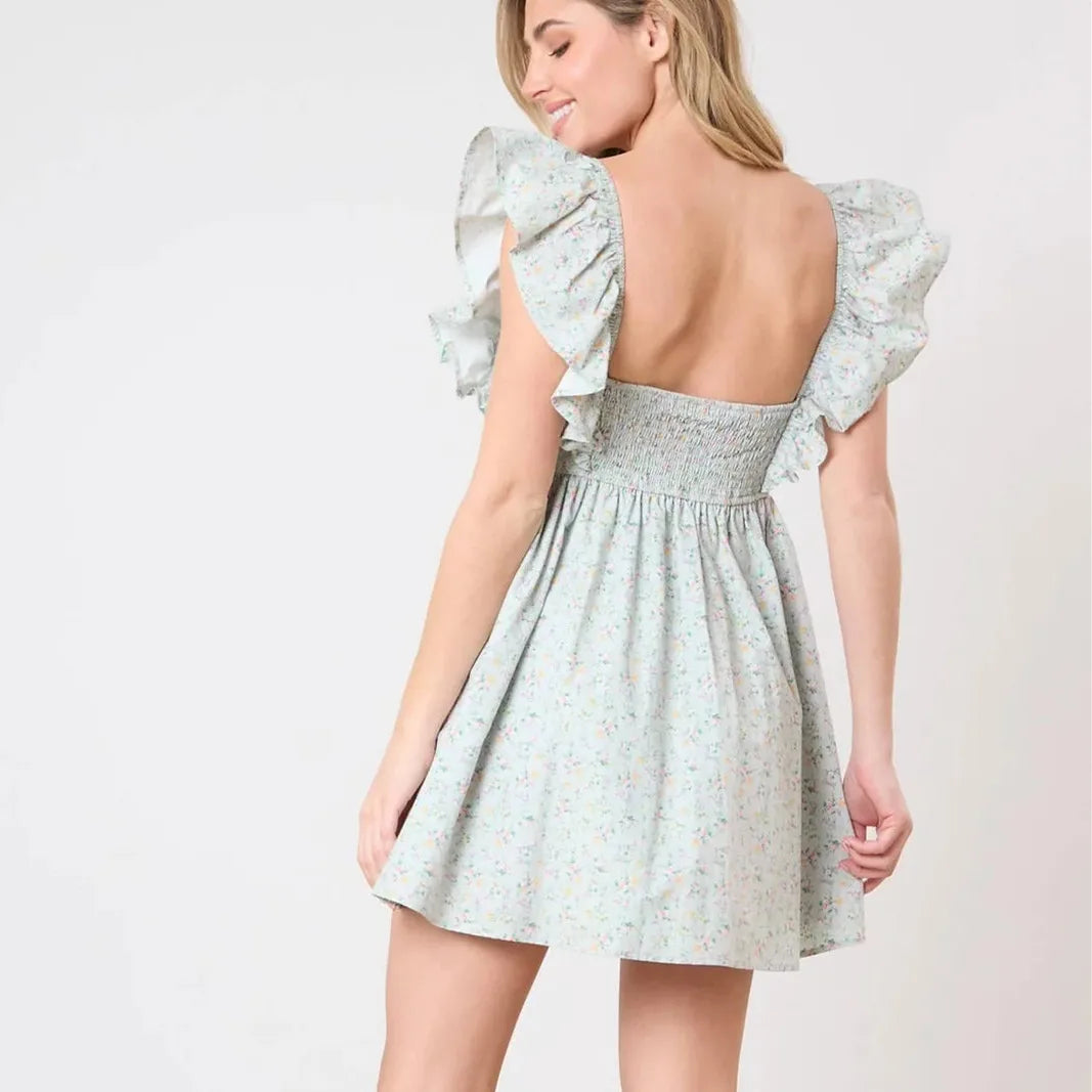 Women's charming green mini dress with bow and ruffles.
