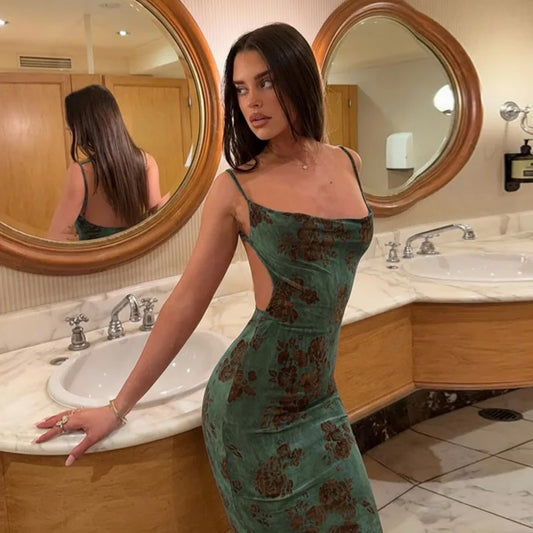 Close-up of a woman in a green floral maxi dress with an open back, showing the spaghetti strap detail and scoop neckline.